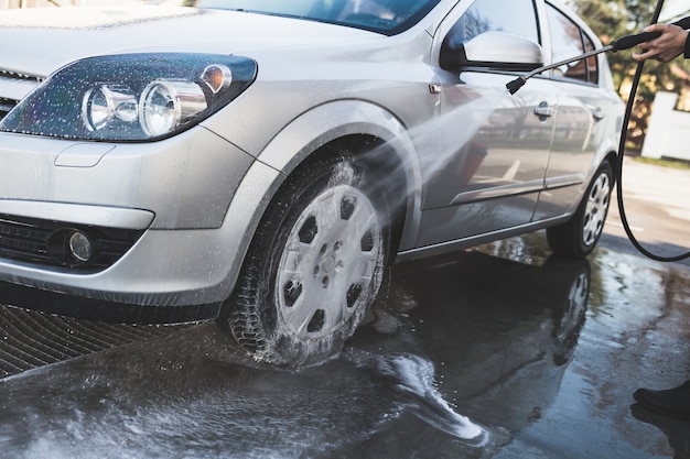 Lavaggio auto. Pulizia auto utilizzando acqua ad alta pressione. Messa a fuoco selettiva.