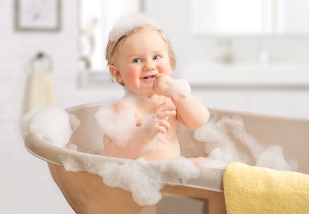 Lavaggio del bambino in un bagno in schiuma.