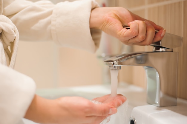 Lavaggio delle mani con sapone sotto acqua corrente