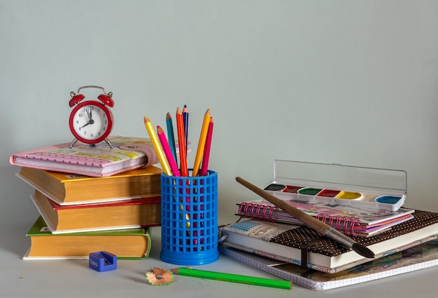 Lavagna, libri di testo, quaderni, matite, un globo e una mela