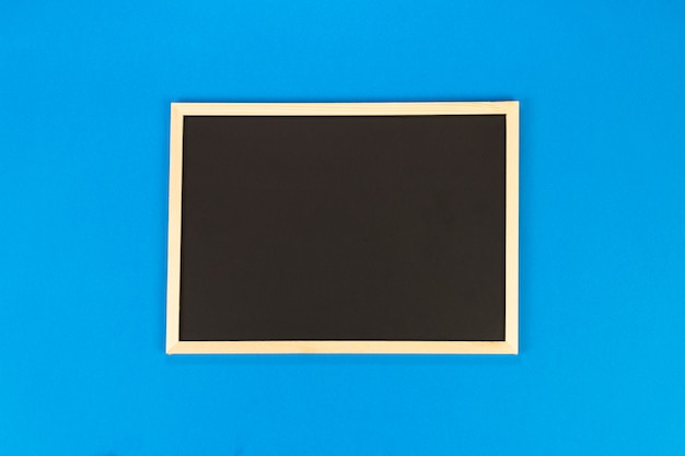 Lavagna vuota su sfondo blu con spazio di copia.