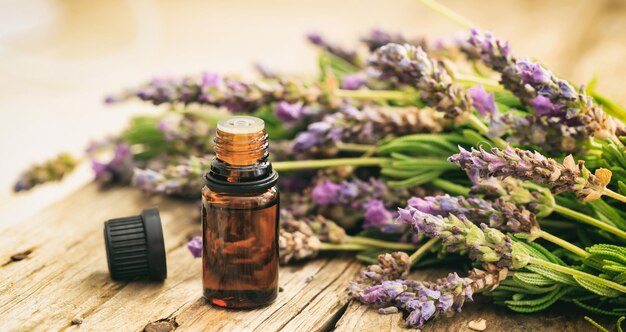 Lavanda fresca e olio essenziale su sfondo di legno