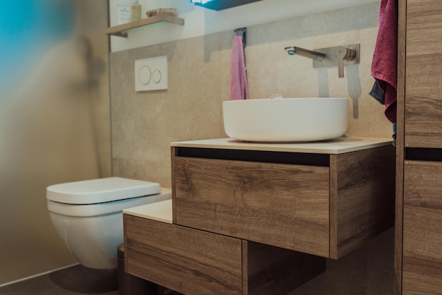 Lavandino bianco su bancone in legno con uno specchio rotondo appeso sopra di esso Interno del bagno