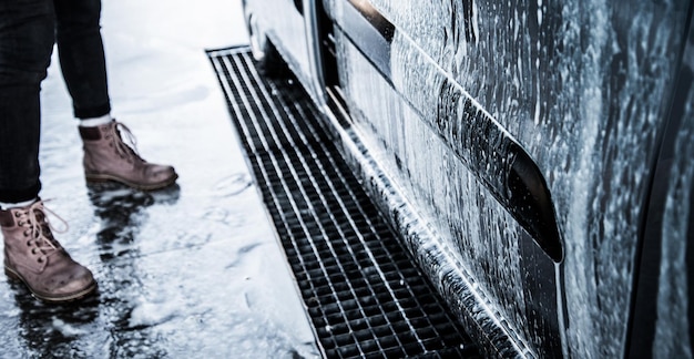 Lavare l'auto con il sapone. Primo piano concetto di auto pulita all'autolavaggio.