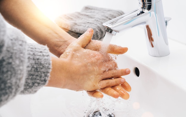 Lavare le mani donna sapone con acqua corrente al lavandino, igiene delle mani prevenzione Coronavirus 2019-ncov. Protezione dalla pandemia di Corona Virus pulendo frequentemente le mani.
