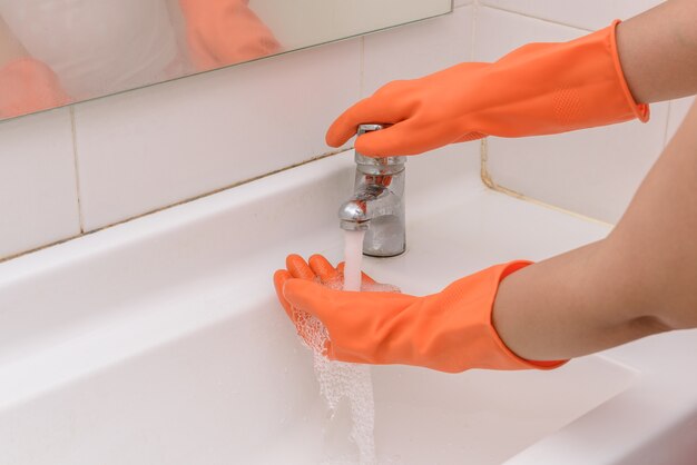 Lavarsi le mani con lo streaming di acqua in bagno. Concetto di igiene