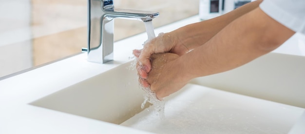 Lavarsi le mani con sapone liquido e acqua di rubinetto Concetto di igiene personale e sanitario antisettico