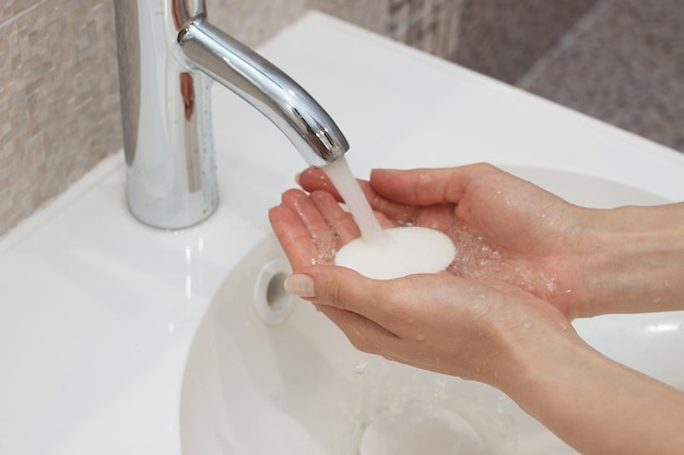 Lavarsi le mani con sapone sotto l'acqua corrente