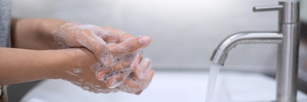 Lavarsi le mani strofinando con la tecnica corretta del sapone sotto il lavandino del bagno per prevenire l'epidemia di coronavirus (covid-19) antibatterico. Prevenzione della malattia influenzale.