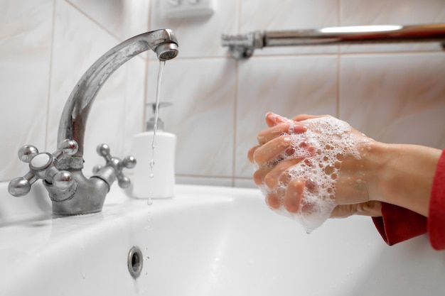 Lavarsi le mani strofinando con sapone uomo per l'igiene della prevenzione del coronavirus per fermare la diffusione del COVID19