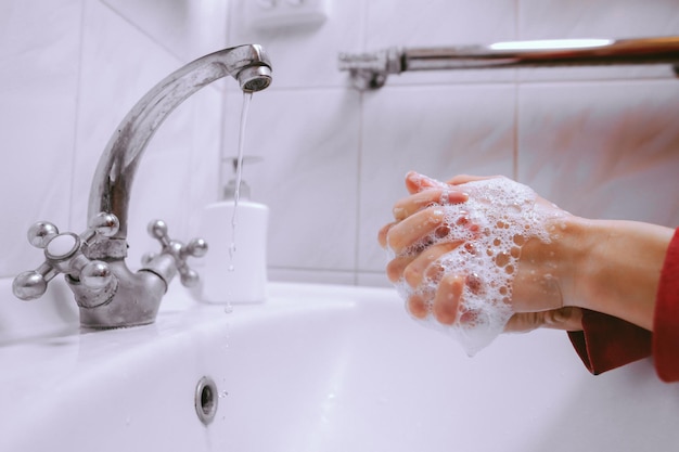 Lavarsi le mani strofinando con sapone uomo per la prevenzione del coronavirus elaborazione di foto d'epoca