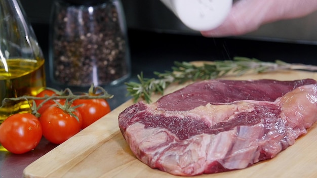 Lavorando in cucina lo chef prepara la carne salandola