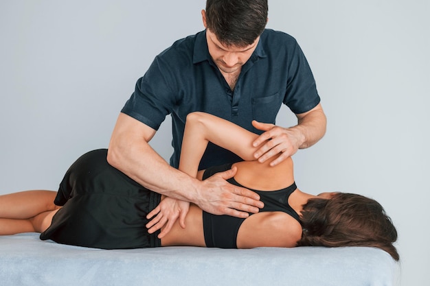 Lavorare con la colonna vertebrale e il collo Donna in visita fisiologa che fa massaggi e aiuta con i traumi