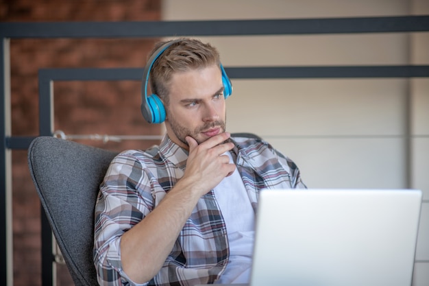 Lavorare da remoto. Un giovane premuroso che lavora concentrato da casa