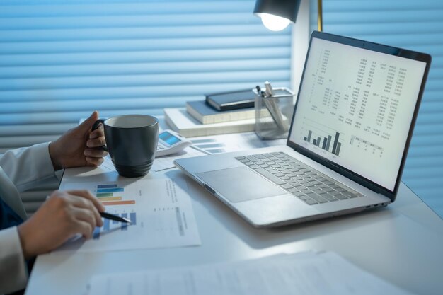 Lavorare da solo fino a tarda notte Donna d'affari asiatica sul posto di lavoro in ufficio lavorare a tarda notte alla scrivania in un ufficio buio lavorando su un laptop la sera tardi