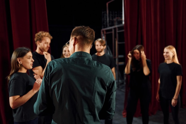 Lavorare insieme Gruppo di attori in abiti scuri durante le prove a teatro