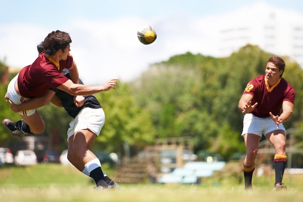 Lavorare insieme per una maggiore unità Inquadratura di un giovane giocatore di rugby che esegue un passaggio a metà contrasto