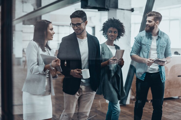 Foto lavorare oltre i bordi di una scrivania. gruppo di giovani in abbigliamento casual intelligente