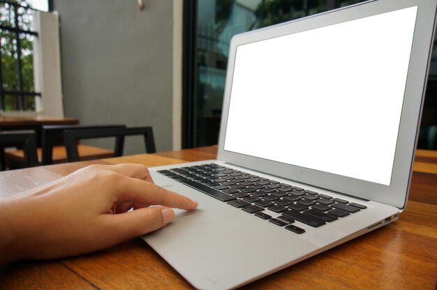 Lavorare usando un computer portatile su un tavolo di legno, scrivere a mano su una tastiera.