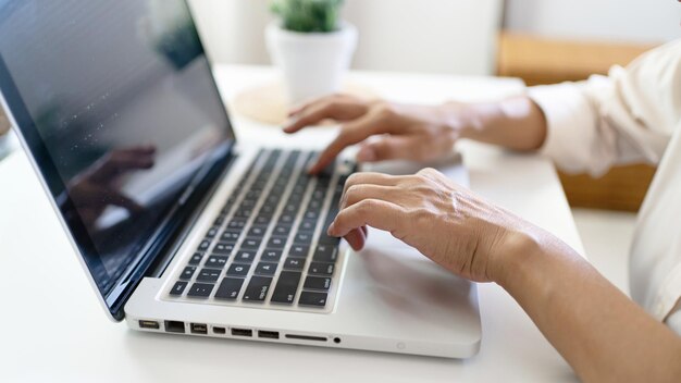 Lavorare utilizzando un computer portatile su un tavolo di legno Mani che digitano su un concetto di e-commerce di tecnologia della tastiera