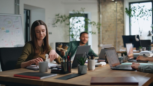 Lavoratore amichevole che porta il caffè ai colleghi di lavoro nella squadra di ufficio dello spazio di coworking