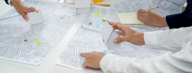 Lavoratore architetto e ingegnere che lavora su un progetto di costruzione immobiliare pianificazione oratoria con cartografia e mappa cadastrale dell'area urbana della città per guidare il piano aziendale di costruzione dello sviluppatore della città