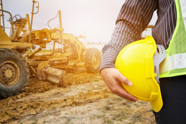 Lavoratore asiatico dell'ingegnere edile dell'uomo di affari con il casco protettivo giallo al cantiere