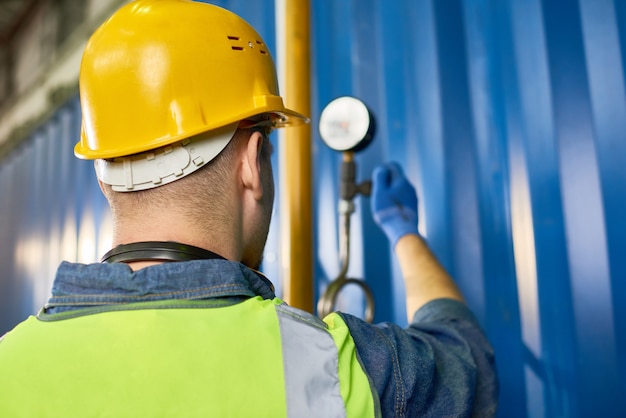 Lavoratore che controlla attrezzatura nello stabilimento