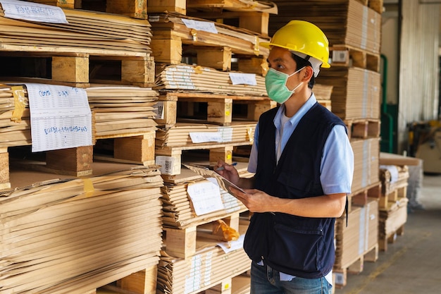 Lavoratore che controlla la materia prima in negozio per l'industria della fabbrica, ingegnere della sicurezza