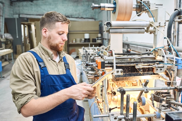 Lavoratore che fa funzionare macchina moderna alla fabbrica