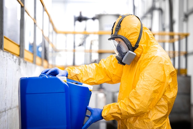 Lavoratore che indossa dispositivi di protezione e maschera antigas che lavora nella fabbrica di produzione di prodotti chimici