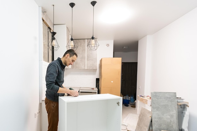 Lavoratore che installa un nuovo piano di lavoro nella cucina moderna.