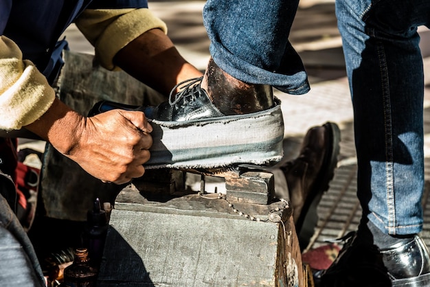 lavoratore che lucida un paio di scarpe