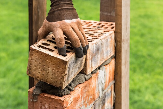 Lavoratore che mette i mattoni sul mortaio