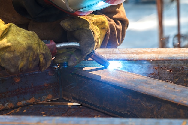 Lavoratore che salda in una fabbrica. Saldatura su un impianto industriale.