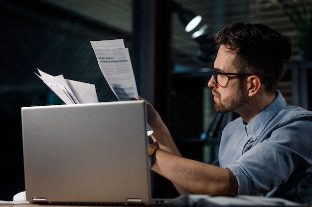 Lavoratore con documenti e laptop