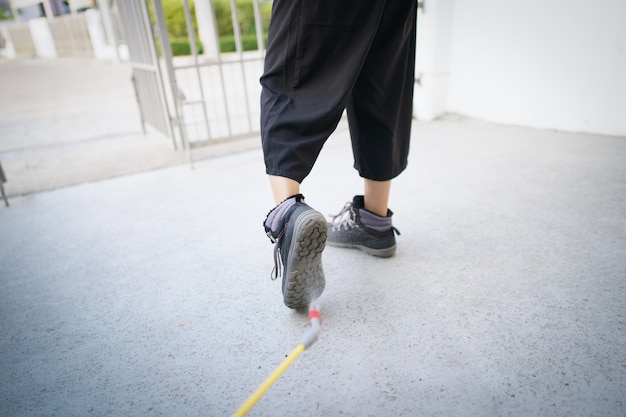 Lavoratore con spray detergente igienizzante chimico per disinfettare il patogeno del virus COVID-19 sulle scarpe.