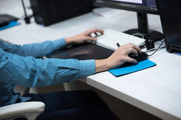 lavoratore creativo, editor di foto che lavora su tavoletta grafica sul suo computer desktop in un piccolo ufficio di avvio