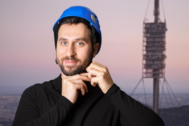 Lavoratore della torre dell'uomo Lavoro in altezza Antenna radio Indossa un casco un casco protettivo