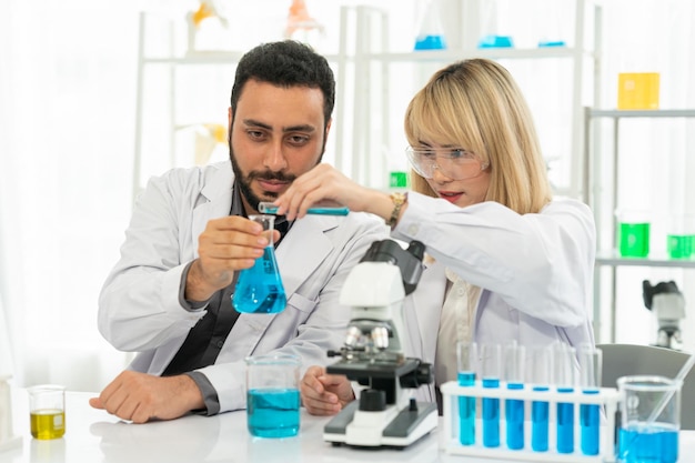 Lavoratore di laboratorio utilizzando la lente d'ingrandimento sul microscopio