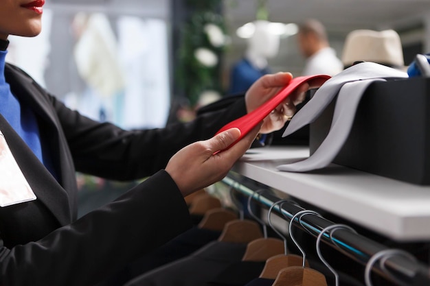 Lavoratore di una boutique che controlla la cravatta rossa da vicino