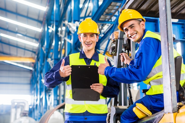 Lavoratore e carrellista in fabbrica industriale