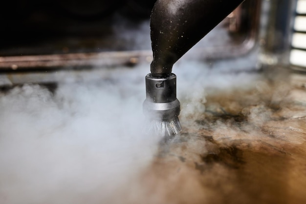 Lavoratore esperto in guanti di gomma per la pulizia a vapore delle attrezzature da cucina