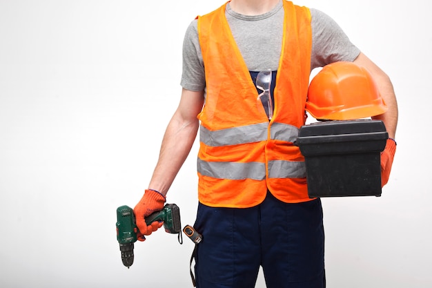 lavoratore in uniforme professionale con cassetta degli attrezzi in mano su sfondo grigio