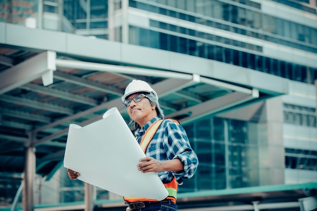 Lavoratore manuale con un progetto in piedi sul cantiere