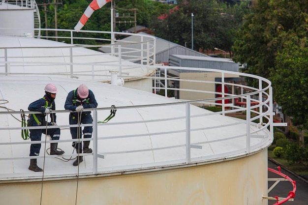 Lavoratore maschio che indossa la prima imbracatura di sicurezza e la sicurezza che lavora al corrimano alto