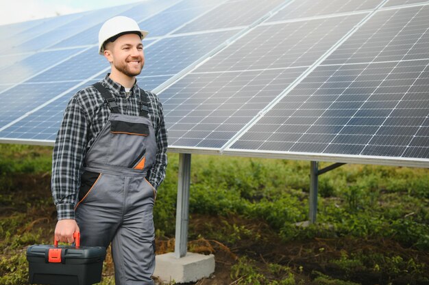 Lavoratore maschio in uniforme all'aperto con batterie solari in una giornata di sole