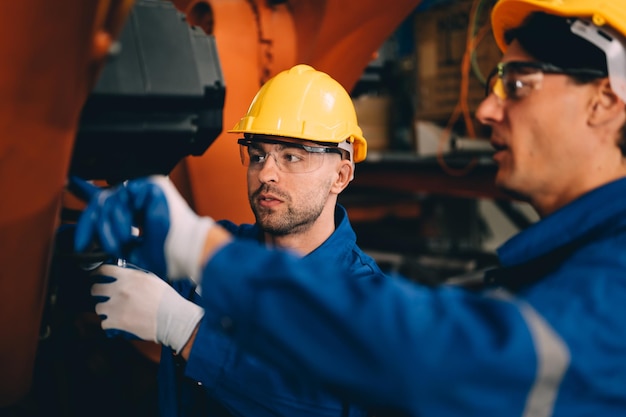 Lavoratore professionista manutenzione macchina bracci robotici macchinari industriali Tecnico che lavora