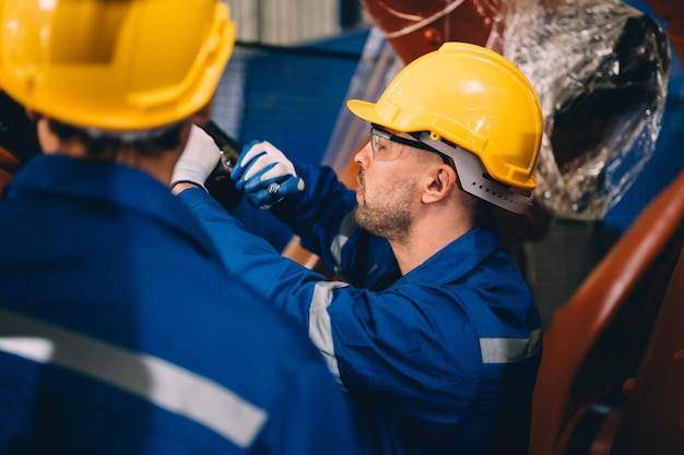 Lavoratore professionista manutenzione macchina bracci robotici macchinari industriali Tecnico che lavora