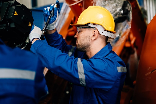 Lavoratore professionista manutenzione macchina bracci robotici macchinari industriali Tecnico che lavora